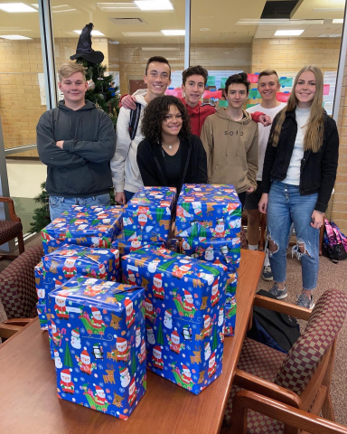 Students pose with wrapped presents.