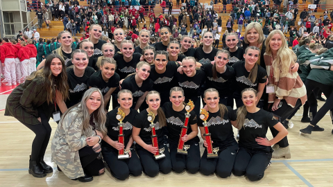 The drill team poses with trophies and awards.