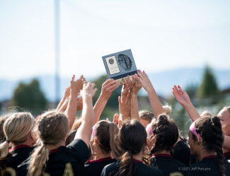 MMHS girls soccer team hold region trophy.