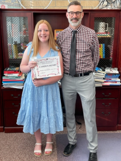 Principal Bradshaw awards Camden Henry an award for 100 percent attendance for the 2022 - 2023 school year.