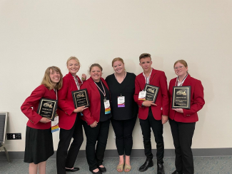 FCCLA members and FFCLA advisor from Maple Mountain High School holding awards at FCCLA Nationals.