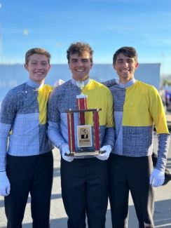3 students holding a trophy